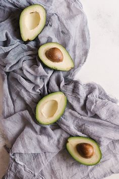 an avocado cut in half sitting on top of a cloth