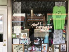 the front window of a barbershop with pictures and memorabilia on display in it