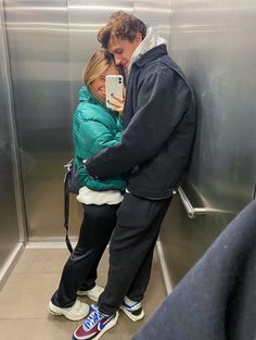 a man and woman standing next to each other in an elevator