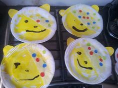 paper plates with faces on them sitting on top of an oven