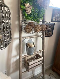 an old ladder is used as a shelf with baskets on it and hanging from the wall