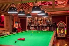 a green pool table in a room with two lamps hanging from it's ceiling