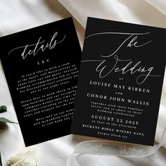 two black and white wedding cards with calligraphy on them, next to a flower