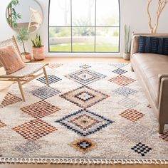 a living room area with a couch, chair and rug in front of a large window