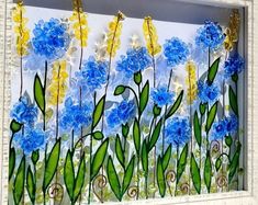 blue flowers and green leaves are painted on a glass paneled window with white frame