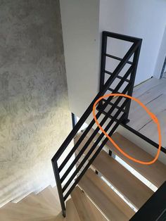 an orange circle is in the middle of a stair case that has been painted black