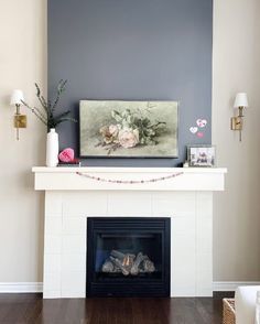 a white fireplace with a painting on the mantle