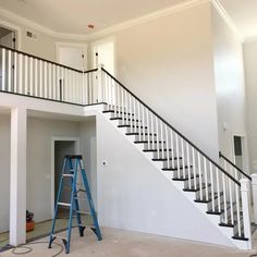 an empty room with stairs and a ladder