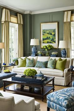 a living room filled with lots of furniture next to two lamps and paintings on the wall