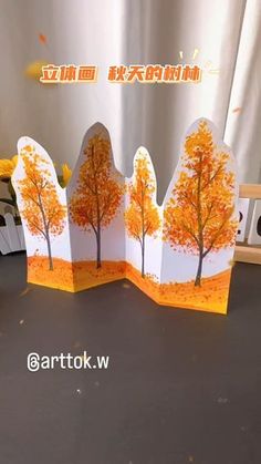 an open card with trees on it and the words autumn written in chinese above them