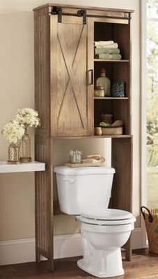 a white toilet sitting next to a wooden cabinet