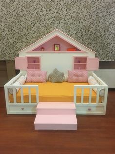 a dollhouse bed with pink and yellow furniture