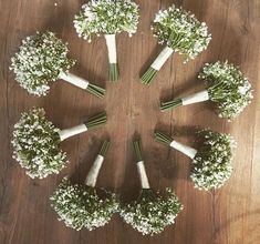 a group of flowers arranged in the shape of a circle on top of a wooden floor