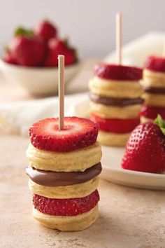 strawberry shortcakes stacked on top of each other with strawberries in the background