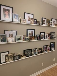 a wall filled with lots of pictures and framed photos on top of white floating shelves