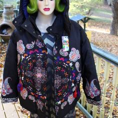 A Beautiful Boho Style Winter Ladies Jacket. Zippered Removable Hood. The Maker Is Desigual. Tag States Padded Emotion. There Are All Types Of Designs On The Jacket . Front, Back, Sleeves. Believe A Medalion Of Some Sort. Lots Of Paisley Or Swirls. Front Pockets Are Slant With Zipper For Closure. There Are Tassels On The End Of The Zippers. The Color Is Black. The Other Colors Are Many Including Some Not All: White, Red, Pink, Blue Green. The Sleeve Cuffs Are Embroidered. The Size On Label Of Ja Black Winter Festival Outerwear, Bohemian Hooded Outerwear For Spring, Multicolor Outerwear With Adjustable Hood For Fall, Multicolor Fall Outerwear With Adjustable Hood, Fall Multicolor Outerwear With Adjustable Hood, Hooded Outerwear With Pockets For Festival, Bohemian Long Sleeve Outerwear For Streetwear, Black Bohemian Outerwear For Outdoor, Multicolor Winter Outerwear With Adjustable Hood