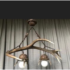 an antler chandelier with three lights hanging from it