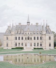 a large castle like building sitting on top of a lush green field