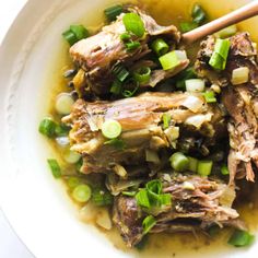 a white bowl filled with meat and vegetables