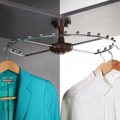 two shirts hang on clothes racks in front of a white wall and a blue blazer