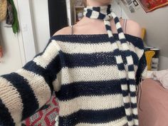 a woman wearing an off the shoulder striped sweater