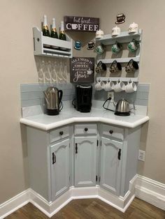 a kitchen with white cupboards and shelves filled with coffee pots, tea kettles and cups