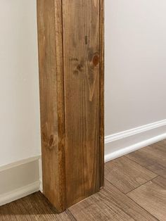 a tall wooden cabinet sitting on top of a hard wood floor