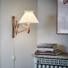 a lamp that is on the side of a wall next to some books and a radiator