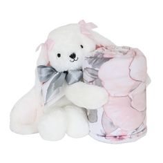 a white teddy bear sitting next to a pink and gray blanket with flowers on it