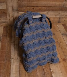 a blue and gray bag sitting on top of a wooden floor next to a wall