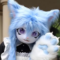 a close up of a doll with blue hair and purple eyes wearing a cat costume