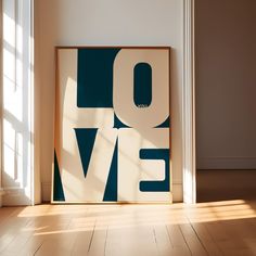 an art print with the word love on it in front of a door and window