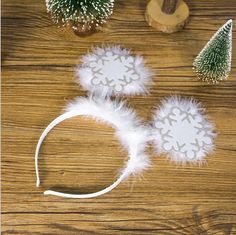 two white snowflake headbands sitting on top of a wooden table