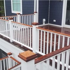 a deck with white railings and wooden steps