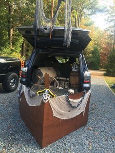 the back end of a vehicle with its trunk open and rope hanging from it's roof