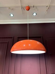 an orange light hanging from the ceiling in a room