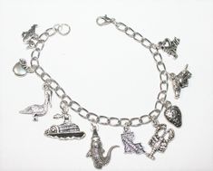 "This Louisiana State charm bracelet is handcrafted using Rhodium Finished Nickel Free Cable Chain, 10 nickle free zinc alloy charms, Duck Charm, Tomato Charm, Pelican Charm, Louisiana State Charm, Steamboat Charm, Alligator Charm, I Love Jazz Charm, Lobster Charm, Strawberry Charm, Wild Boar Charm, Lobster Clasp This bracelet measures approx 7 - 1/2 \" in length. You have the option to choose other bracelets sizes and also to add an initial charm When purchasing a bracelet for someone other tha Novelty Silver Charm Bracelet Gift, Silver Novelty Charm Bracelet Gift, Silver Novelty Charm Bracelet As A Gift, Handmade Novelty Silver Bracelets, Novelty Metal Charm Bracelet As Gift, Novelty Metal Charm Bracelet Gift, Novelty Metal Jewelry With Charms, Silver Metal Novelty Bracelets, Novelty Silver Hypoallergenic Charm Bracelet