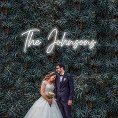 a bride and groom standing in front of a wall with the words, the johnsons