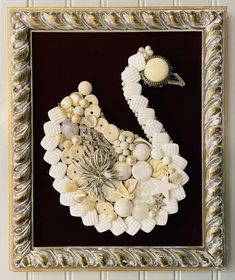 there is a framed picture with buttons and shells on the bottom, along with a ring in the middle