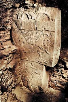 an ancient stone carving in the middle of a rock formation with carvings on it's sides