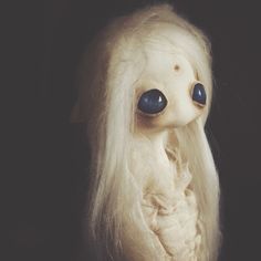 a white stuffed animal with long hair and big eyes