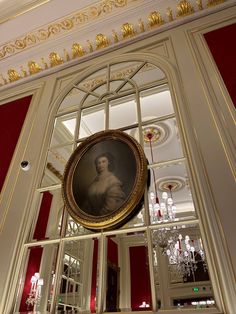 a portrait hangs on the wall in an ornately decorated room