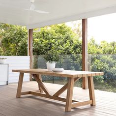 a wooden table sitting on top of a hard wood floor next to a white wall