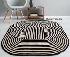 a black and white area rug with an interlocked design on the floor next to a chair