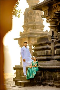 a man and woman sitting on some steps