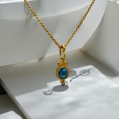 This elegant 24K gold-plated necklace features a stunning aquamarine stone framed with a delicate diamond accent, set on a silver base. Inspired by ancient designs, this handcrafted pendant combines timeless beauty with modern craftsmanship. Perfect for adding a touch of luxury to any outfit or as a meaningful gift, this necklace is both a fashion statement and a piece of art. Ideal for everyday wear or special occasions, it's a treasure to be cherished for years Ancient Designs, Aquamarine Pendant, Aquamarine Stone, Gold Plated Necklace, Meaningful Gifts, Timeless Beauty, Pendant Necklaces, Fashion Statement, Gold Diamond