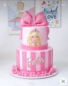 a pink and white cake with barbie on it