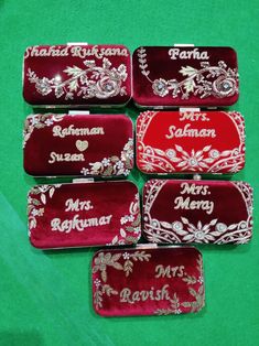 six personalized red and white trays on a green table with the names of each individual