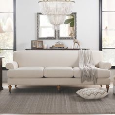 a living room filled with furniture and a chandelier hanging over the top of it