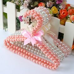 pink and white hair clips with bows on them next to flowers in a vase filled with roses